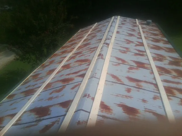 Rusted metal roof panels with new wood purlins before replacement — Storm Damage Roof Repair in Garrison by Roofing Brothers
